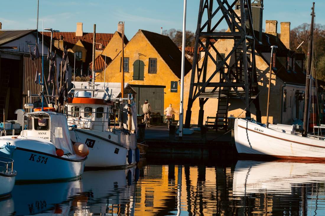 Fiskekuttere spejler sig i Dragør Havn i det gyldne lys